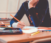 Image of a child drawing in a class room